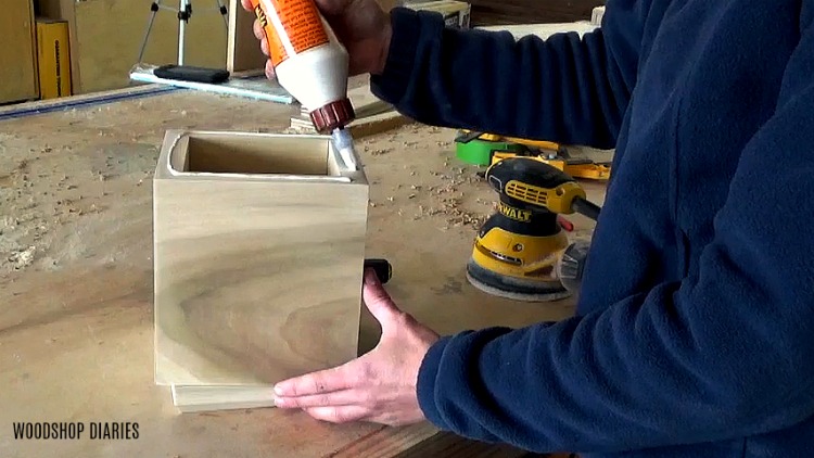 Applying wood glue to attach top of the urn